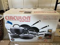 Box of Circulon Espree 10-piece hard anodized cookware set featuring pots, pans, and glass lids with black handles