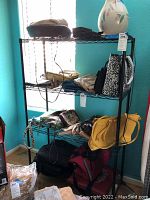Full view of Hypertough black metal rack shelving unit holding various bags and decorative items, contents excluded from sale.
