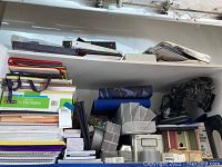 Full view of stacked notebooks, file folders, binders, storage baskets, and metal bookends