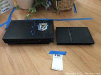 Sony PlayStation 2 and Samsung TV together on floor, showing overall lot contents