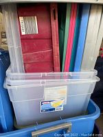 Stacked storage bins and lids showing clear bins, colorful lids in red, blue, and green.
