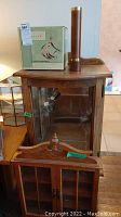 Photo shows wooden display cabinets and a copper-colored wooden-handled kaleidoscope on top, giving an overview of all items in the lot.
