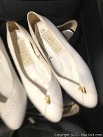 White ladies flat shoes with gold ornament on front