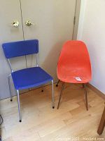 Image showing two chairs side by side: an orange vintage tub style chair and a blue chair with metal frame.