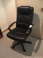 Black high back office chair shown from a side angle, highlighting armrest and seat padding.