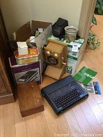 Lot overview showing multiple items including typewriter, phone, cassette player, shredder, calculator, and accessories.