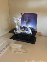 Swarovski kudu crystal figurine on black crystal display stand with engraved plaque 'Inspiration Africa'. Background includes original box.