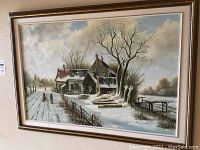 Full view of framed oil painting showing winter farmhouse with two people walking on path in snow, rustic buildings, bare trees, and cloudy sky.