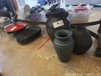 Photo showing all three ceramic pots arranged on the floor with some background household items.