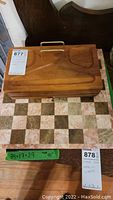 Top view of wooden organizer box closed on top of marble chessboard showing checkered pattern.
