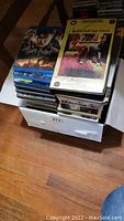 Stack of various DVDs and VHS including Harry Potter and Rock 'n' Roll High School