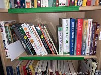 Shelf with multiple books related to cancer and health showing various titles and authors