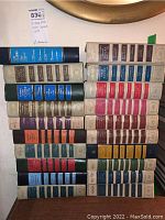 Photo showing multiple stacks of vintage Reader's Digest condensed books arranged on a floor with a visible tag.