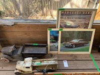Wide shot showing three vintage metal toy vehicles and three framed prints including a Mercedes Benz racing poster and classic cars.