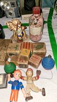 Photo showing various vintage wooden toys including blocks, spinning tops, and colorful character figures.