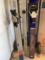 Four water skis leaning against wall, showing bindings and brand markings including SPIEGL and Water Ski made in Norway.