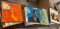 Top-down view of multiple Nat King Cole LP records stacked next to other vintage LP collections, showcasing the variety and condition of the records in the lot.