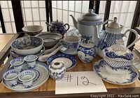 Full collection of vintage blue and white porcelain tea sets and collectibles on table.