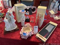 Overview photo showing all items in the lot: Belcari statue, Lenox vases, ceramic bowl, Lenox cleaver, glass vase, glass paperweights.