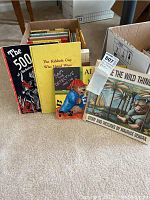 Photo showing assorted children's books including 'Where the Wild Things Are', 'The 500', 'The Kid who Hated Wine' and 'Say Detective'. Books are boxed, used condition.