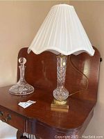 Full view of the decanter and lamp on a wooden surface showing their sizes and appearance