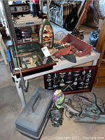Photo showing the full lot on a white table and floor, including two shadow boxes, tackle box, fish and crab decorations, and other nautical decor