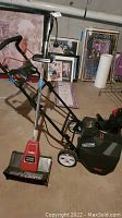 Photo showing both the Craftsman cordless snow thrower and the Toro electric power shovel together in a basement setting.
