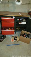 Full workbench area showing tools in chest drawers, boxes on floor, and power tools on shelf
