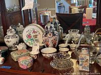 Full assortment of vases, jars, trinket boxes, plates and bowls on mahogany surface
