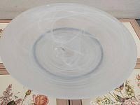 Top view of the frosted glass platter showing swirl pattern and center sticker.