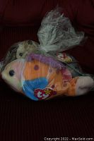 Photo of Lips TY Beanie Baby fish plush sealed in plastic, showing colorful fish design and TY heart tag.