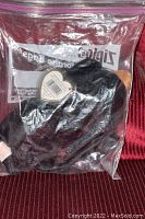Ty Beanie Baby Blackie stored inside a sealed Ziploc plastic bag showing the heart-shaped Ty tag clearly visible.