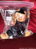 Doby Ty Beanie Baby dog plush inside a clear resealable plastic bag with visible Ty heart tag, showing black and tan coloring.