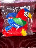 Front view of the Ty Beanie Baby Jabber parrot plush in sealed plastic bag, showing vibrant colors and intact condition.