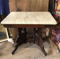 Full view of the East Lake style marble top table showing the rectangular white marble top and wooden base with carved legs.