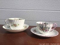 Two Shelley England bone china cups and saucers displayed side by side showing floral patterns and gold trim.