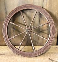 Front view of wooden spinning wheel head showing eight turned spokes and outer rim.
