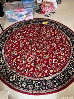 Full view of the round area rug showing the entire floral pattern and border with items around it for scale.