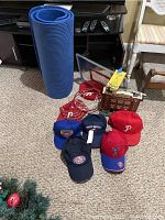 Photo showing blue yoga mat, door hanging basketball hoop, six varied baseball hats, and Fenway Park electronic decoration plugged item.