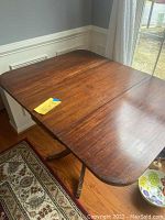 Photo of mahogany drop-leaf table fully extended, showing rich finish and two drop-down leaves extended.