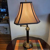 Front view of the brown and gold toned table lamp lit to show shade and base details
