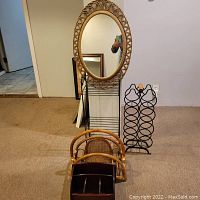 Full view of all items on floor: black metal wine rack, wooden magazine racks, mirror, and remote holder