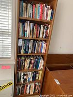 Tall wooden shelves densely packed with mostly hardcover nonfiction books, including visible titles on history, business, and science.