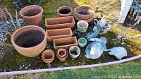 Overview of assorted terracotta pots including large, medium, small round pots and rectangular planters, along with four ceramic or resin garden creatures