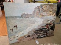 Front view of impressionist style seascape painting on stretched canvas showing boats on the shore and cliffs in background.
