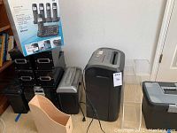 Overview of the lot showing Royal 1620MX shredder, Panasonic cordless phones with main and portable stands, black metal stackable storage boxes of different sizes, and three clear plastic file holders