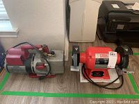 Both Robinair VacuMaster vacuum pump and 6-inch bench grinder side by side