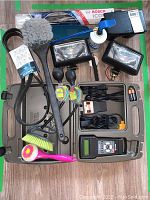 Overall view of diagnostic kit with scanner, lamps, brushes, belt, batteries, and small bottle inside carrying case