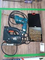 Blue power drill, Black & Decker jigsaw, and gold drill bits in case on wood surface
