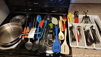 Overview of cooking utensils and two frying pans stacked.